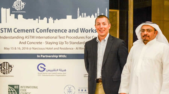 Commercial Specialist standing aside Saudi Arabian Partner in front of project sign
