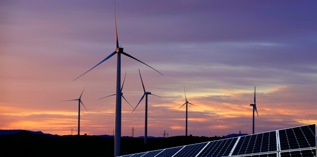 Sunset behind giant windmills producing energy.